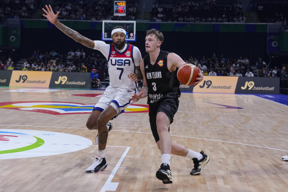 New Zealand forward Finn Delany (3) drives on U.S. forward Brandon Ingram (7) during the first half of a Basketball World Cup group C match in Manila, Saturday, Aug. 26, 2023. (AP Photo/Michael Conroy)