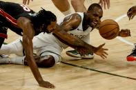 Miami Heat's Trevor Ariza and Milwaukee Bucks' Khris Middleton go after a loose ball during the first half of an NBA basketball game Saturday, May 15, 2021, in Milwaukee. (AP Photo/Morry Gash)