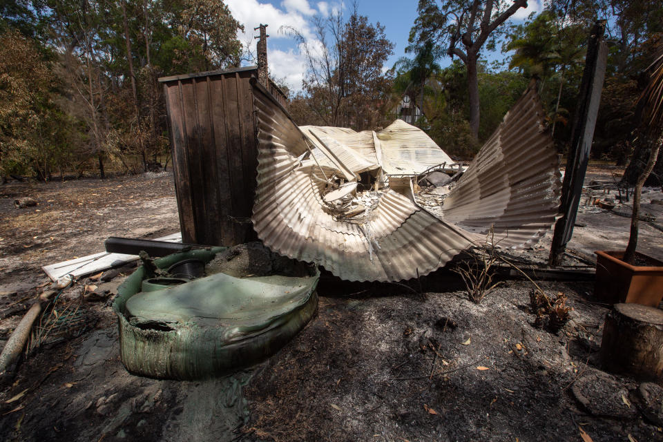 A burnt-out car, cabin and sheds owned by resident Thorsten Kels at Lake Cooroibah Road, Noosa on Monday. Source: AAP/Rob Maccoll
