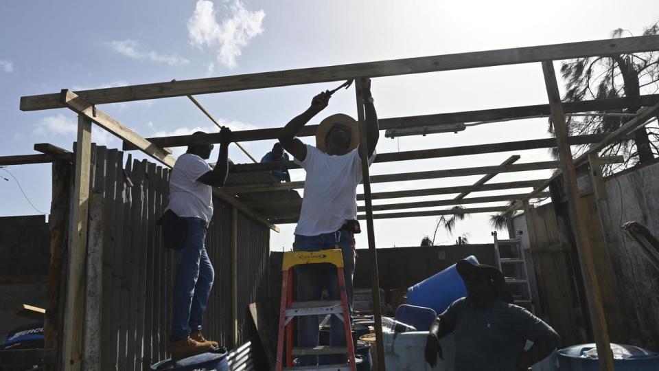 Several people repair a house destroyed by Hurricane Beryl in Jamaica