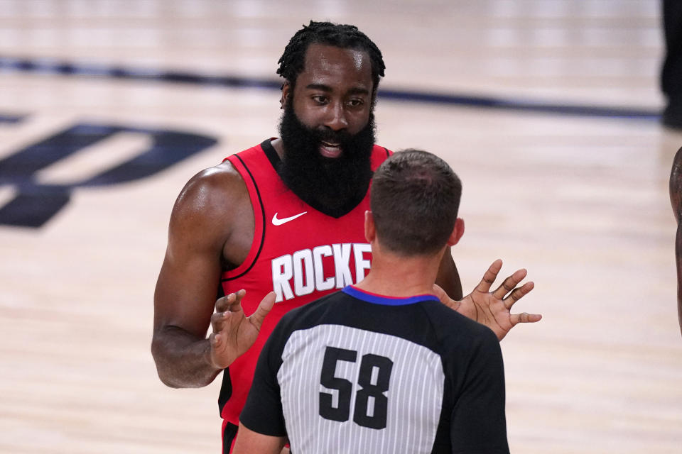 Houston Rockets' James Harden confers with referee Josh Tiven (58) during the first half of an NBA conference semifinal playoff basketball game against the Los Angeles Lakers Sunday, Sept. 6, 2020, in Lake Buena Vista, Fla. (AP Photo/Mark J. Terrill)