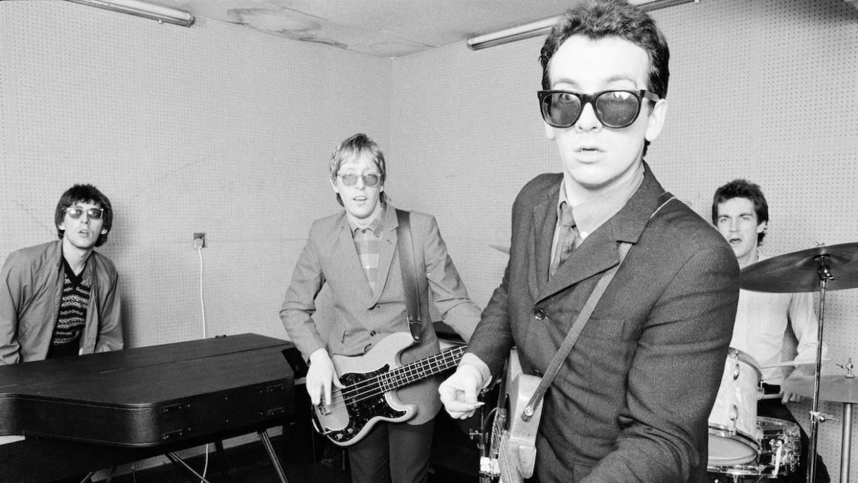  British singer-songwriter Elvis Costello with his backing band The Attractions, UK, 1980. From left to right, keyboard player Steve Nieve, bassist Bruce Thomas, Costello and drummer Pete Thomas. 