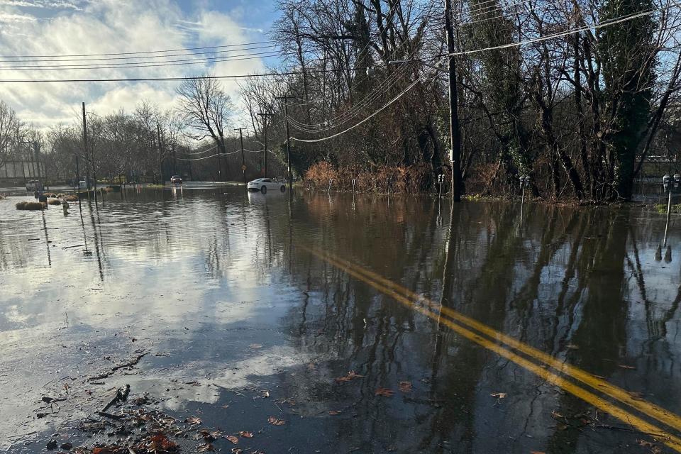 Storm water floods a parking lot and a street in Bronxville, NY, Monday, Dec. 18, 2023. Heavy rain and high winds swept through the Northeast on Monday for the second time in a week, spurring flood warnings, electricity outages, flight cancelations and school closings. (AP Photo/Luke Sheridan)