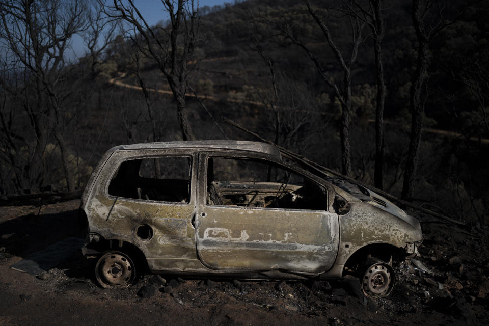 A car burnt by wildfires is pictured in Val de Gilly, southern France, Thursday, Aug. 19, 2021. A fire that has ravaged forests near the French Riviera for four days is slowing down as winds and hot weather subside, but more than 1,100 firefighters were still struggling to get it under control Thursday, local authorities said. (AP Photo/Daniel Cole)