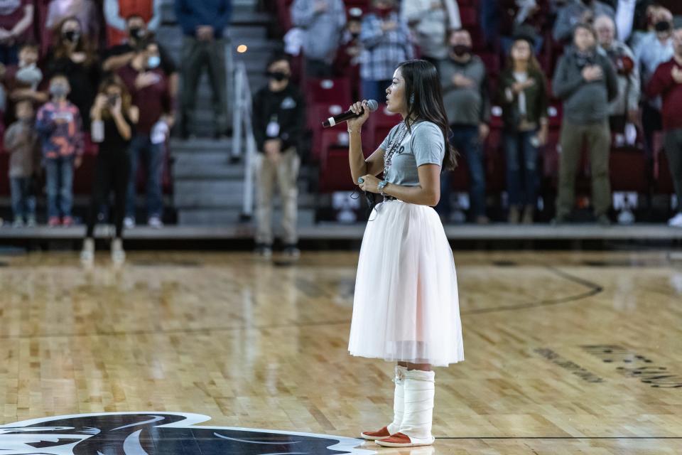 New Mexico State nursing student Vanisha Sam of Coyote Canyon, sings the national anthem in Diné Bizaad before the New Mexico State Aggies face off against the University of New Mexico Lobos at the Pan American Center in Las Cruces on Tuesday, Nov. 30, 2021.