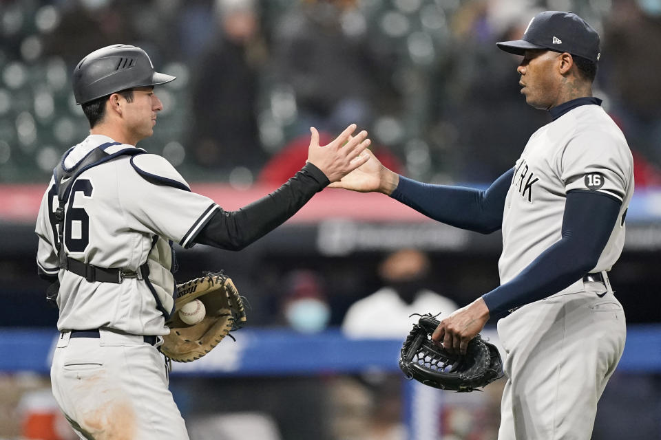 New York Yankees relief pitcher Aroldis Chapman, right, is congratulated by catcher Kyle Higashioka after they defeated the Cleveland Indians in a baseball game, Thursday, April 22, 2021, in Cleveland. (AP Photo/Tony Dejak)