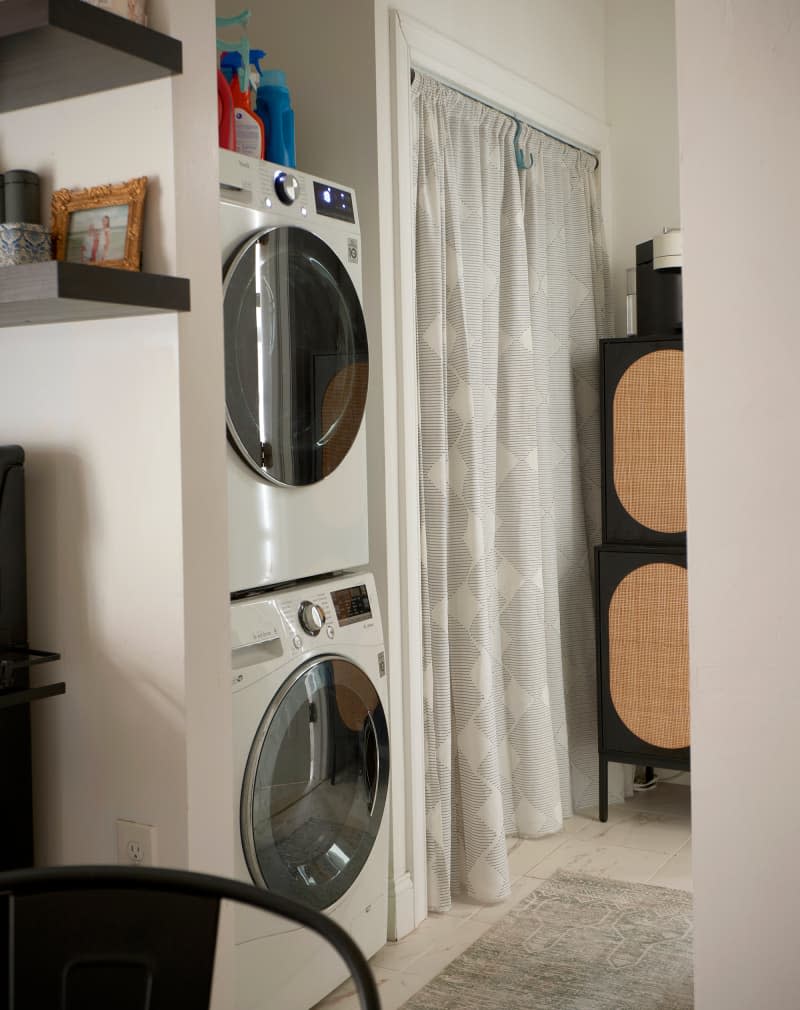 Stacked white washer and dryer in laundry nook.