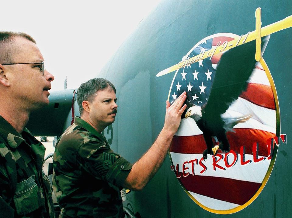 U.S. Air Force Reservists Tech. Sgt. Ron (L) and Staff Sgt. Brian of the 93rd Bomber Squadron apply a decal with the phrase 