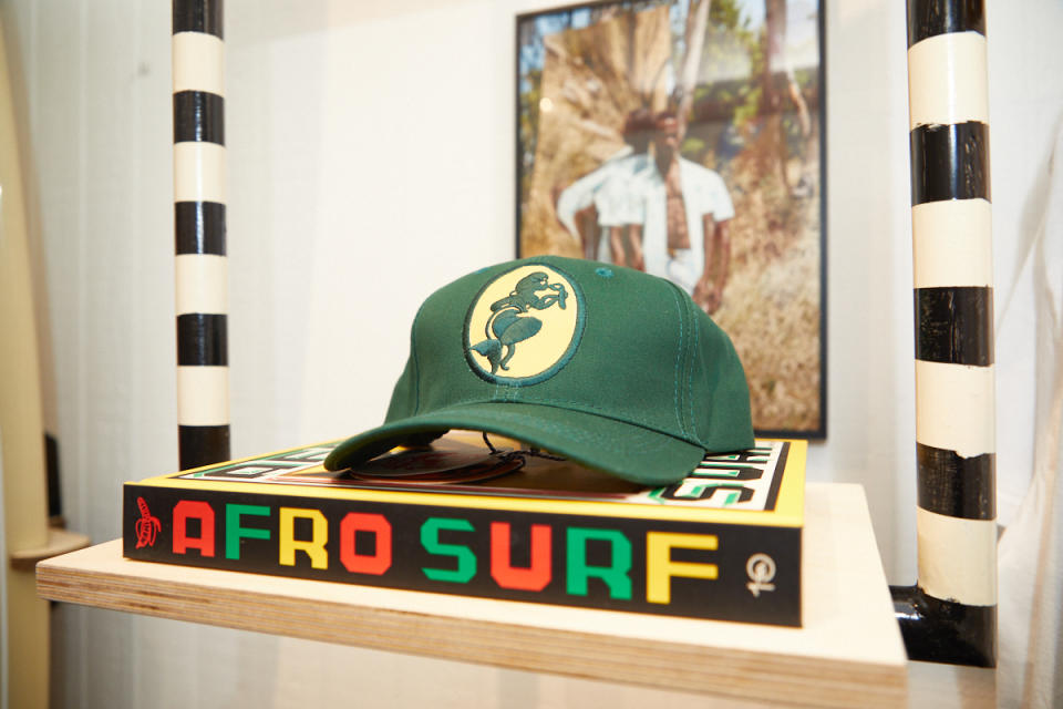 “Afrosurf” book and Mami Wata logo hat. - Credit: Courtesy of Greyson Tarantino/Mami Wata