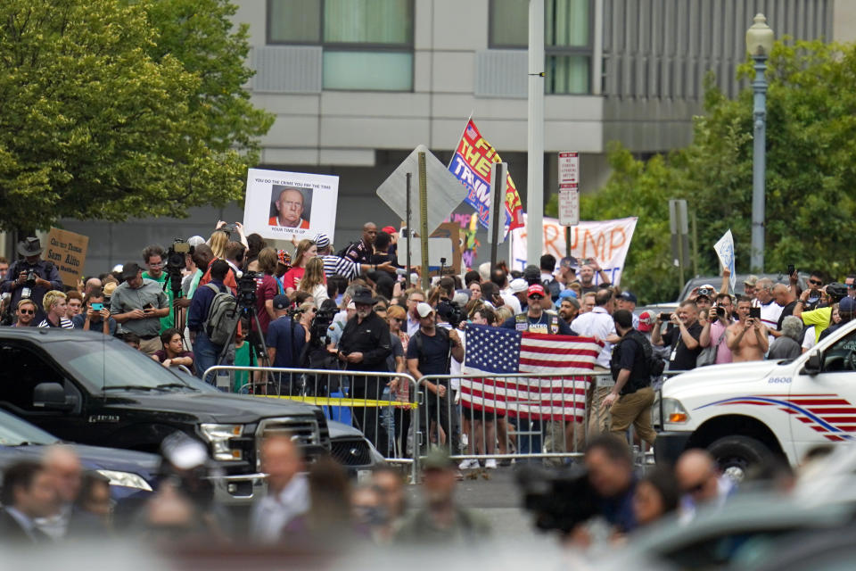 FILE - People watch after former President Donald Trump arrived at the E. Barrett Prettyman U.S. Federal Courthouse, Thursday, Aug. 3, 2023, in Washington, to face a judge on federal conspiracy charges alleging Trump conspired to subvert the 2020 election. (AP Photo/Julio Cortez, File)