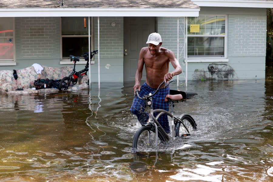 David Lemon walks with his bike past his flooded apartment after Hurricane Idalia passed offshore on August 30, 2023 in Crystal River, Florida. Hurricane Idalia hit the Big Bend area on the Gulf Coast of Florida as a Category 3 storm. (Photo by Joe Raedle/Getty Images)