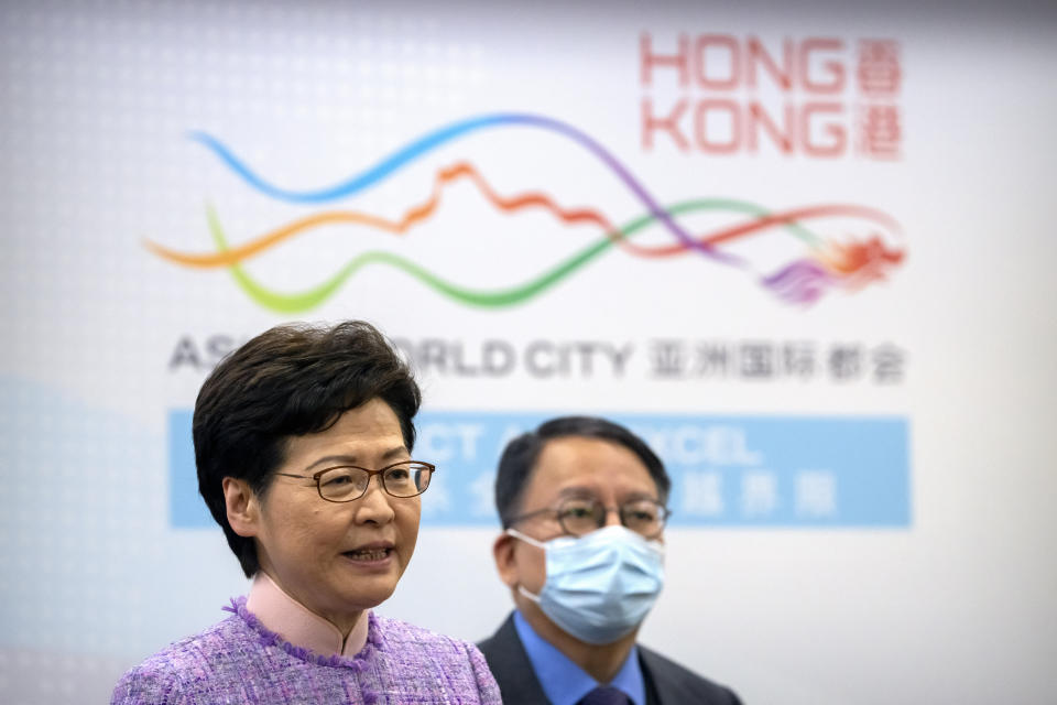 Hong Kong Chief Executive Carrie Lam, left, speaks as Eric Chan, director of the Chief Executive's Office, listens during a press conference in Beijing, Wednesday, Dec. 22, 2021. Hong Kong's leader Carrie Lam met with top leaders in Beijing on Wednesday to report to them on the territory's first legislative elections held under new laws ensuring that only "patriots" loyal to the ruling Chinese Communist Party could run as candidates. (AP Photo/Mark Schiefelbein)