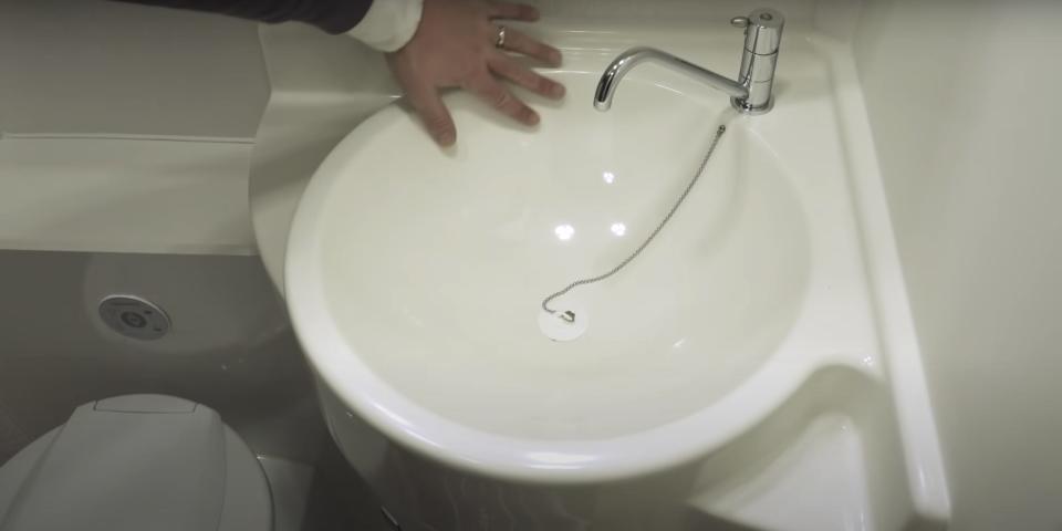 a hand by the sink in the bathroom