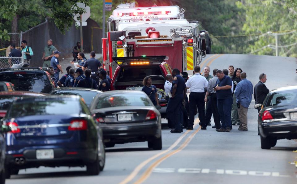 Police investigate the scene of a shooting where five students were shot near Therrell High School in southwest Atlanta on Tuesday, May 13, 2014. Police said their injuries don't appear to be life-threatening and the incident didn't happen on school property. (AP Photo/The Atlanta Journal-Constitution, Ben Gray)