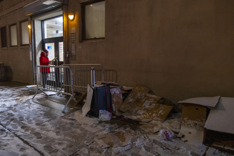 Lincoln Restler, un concejal de la ciudad, reparte calcetines a los migrantes que esperan en una fila organizada por ellos afuera de una oficina de la ciudad para obtener tarjetas de identificación de la ciudad de Nueva York, que les dijeron que podían ayudarles a obtener trabajo, en Brooklyn alrededor de las 2 de la mañana, 16 de enero 2024. (Dakota Santiago/The New York Times).