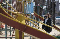 Hazuki Sato, a Futaba town official, visits a playground she used to play daily until she evacuated due to a nuclear scare following a 2011 earthquake, during an interview with The Associated Press in Futaba town, Fukushima prefecture, northeastern Japan, Sunday, Feb. 28, 2021. She's now preparing for the coming-of-age ceremony that is typical for Japanese 20-year-olds, hoping for a reunion in town so she can reconnect with her former classmates who have scattered. (AP Photo/Hiro Komae)