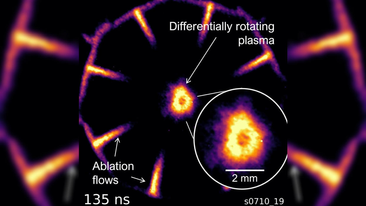  A purple hexon of light surrounding a fuzzy orange ring on a black background 