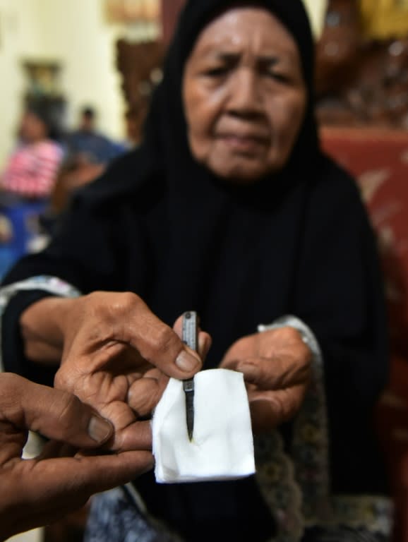 A traditional healer shows a cutting tool used to circumcise girls in Gorontalo, Indonesia