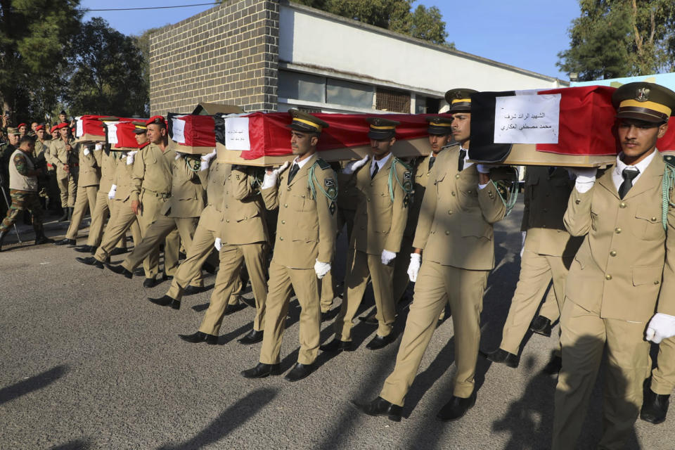 Syrian student officers carry the coffins of their comrades who were killed on Thursday in a drone attack that hit a military graduation ceremony, during a mass funeral procession in Homs, Syria, Friday, Oct. 6, 2023. Family members of some of the victims of deadly drone attacks on a crowded military graduation that killed scores gathered outside a military hospital in this central city Friday to collect the bodies of their loved ones who lost their lives in one of Syria's deadliest single attacks in years. (AP Photo/Abdelrahman Shaheen)