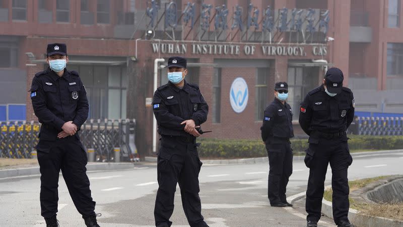 Security personnel gather near the entrance of the Wuhan Institute of Virology during a visit by the World Health Organization team in Wuhan in China’s Hubei province on Wednesday, Feb. 3, 2021.