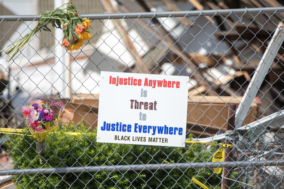 A poster on the fence at the scene of a hate crime reads: Injustice Anywhere is Threat to Justice Everywhere: Black Lives Matter.