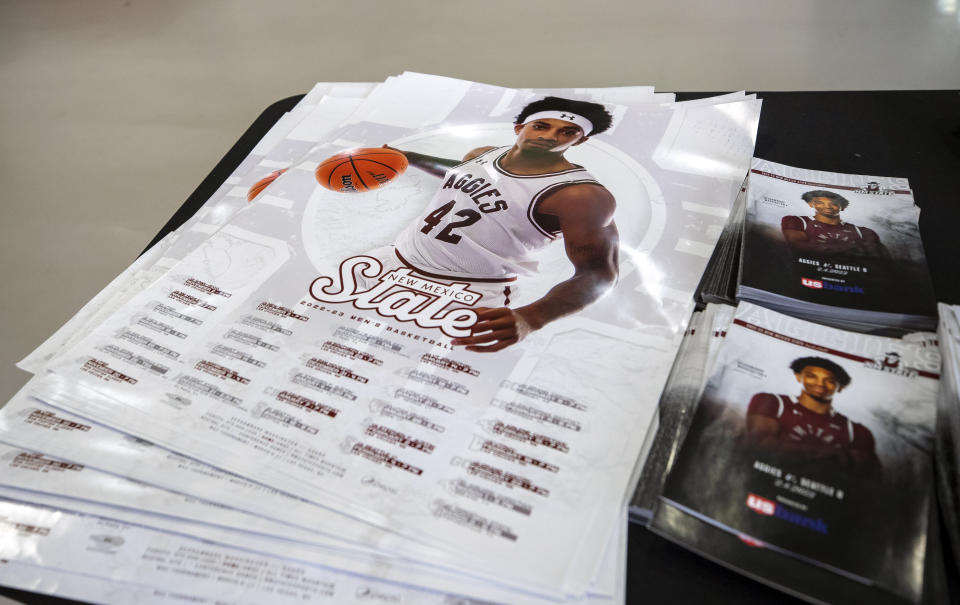 A games calendar, showing a photo of New Mexico State University guard Deshawndre Washington, rests on a table inside the Pan American Center, Wednesday, Feb. 15, 2023, in Las Cruces, N.M. Chancellor Dan Arvizu said at a news conference that he was confident the behavior that led to the cancellation of the men's basketball season and firing of coach Greg Heiar was not reflective of the athletic department or the school overall. (AP Photo/Andrés Leighton)