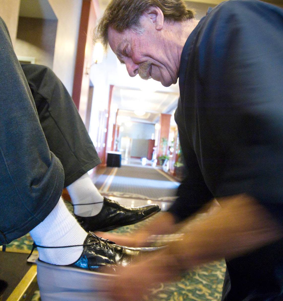 Master bootblack Jim Walker smiles as another happy customer admires his work in this 2013 file photo.