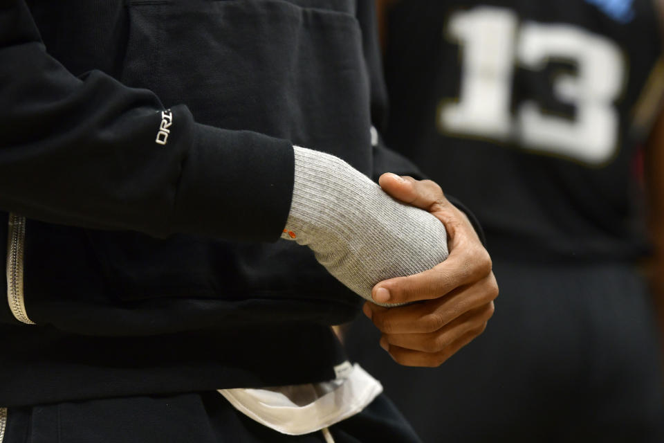 Memphis Grizzlies guard Ja Morant holds his injured hand during the first half in Game 2 of the team's first-round NBA basketball playoff series against the Los Angeles Lakers on Wednesday, April 19, 2023, in Memphis, Tenn. (AP Photo/Brandon Dill)