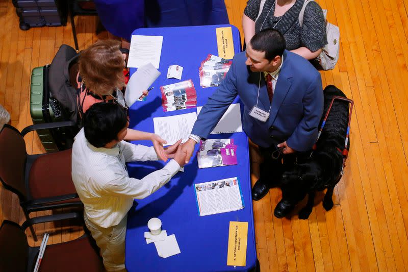 Job seeker Ricardo Scarello talks to representatives from the National Industries for the Blind at the fourth Annual Job Fair for Individuals with Visual Impairments in Cambridge