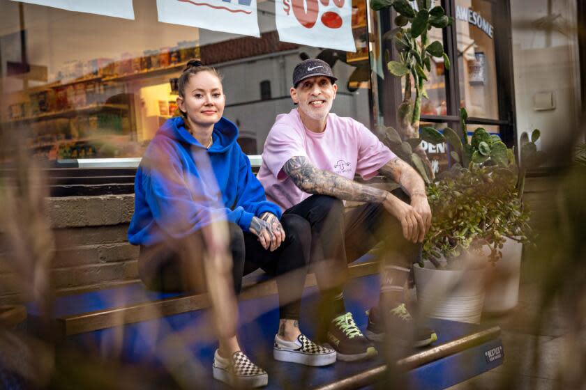 Matt Fontana and Asia Rain sitting for a portrait outside their store.