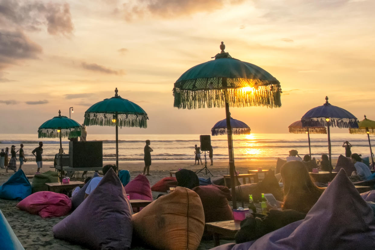 Sunset at Seminyak Beach with tourists lounging around