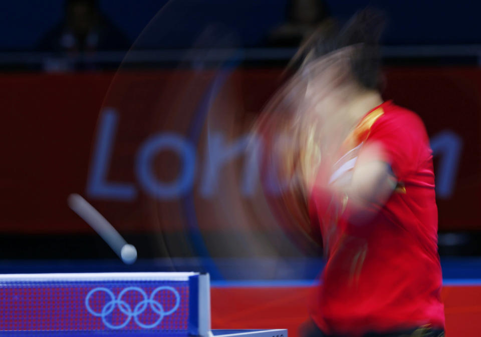 Singapore's Feng Tianwei hits a return to South Korea's Kim Kyungah in their women's team bronze medal table tennis singles match at the ExCel venue during the London 2012 Olympic Games August 7, 2012. Picture taken on slow shutter. REUTERS/Darren Staples (BRITAIN - Tags: OLYMPICS SPORT TABLE TENNIS) 