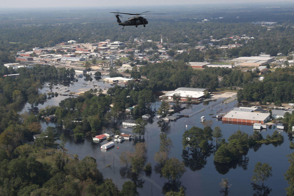 A U.S. Army helicopter flies over homes and businesses flooded by heavy rains from Hurricane Florence in Lumberton, North Carolina. / Credit: Joe Raedle / Getty Images