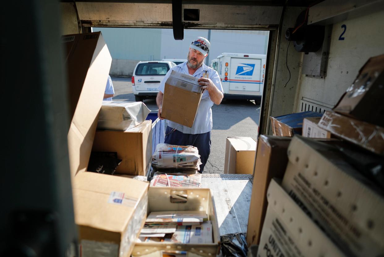 Mail carrier Darryl Glick, 55, of Ashville loads the day's mail for his Madison Mills neighborhood route into to his truck parked behind the South Columbus branch of the United States Postal Service on Wednesday, March 10, 2021. 