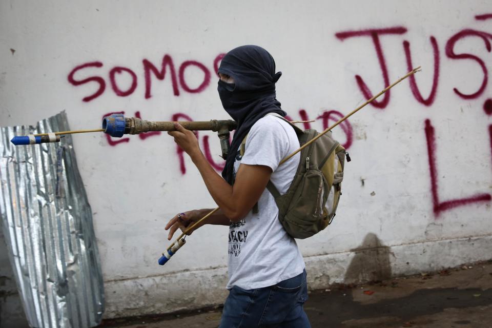 An anti-government protester prepares to shoot firecrackers during a protest against Nicolas Maduro's government in Caracas