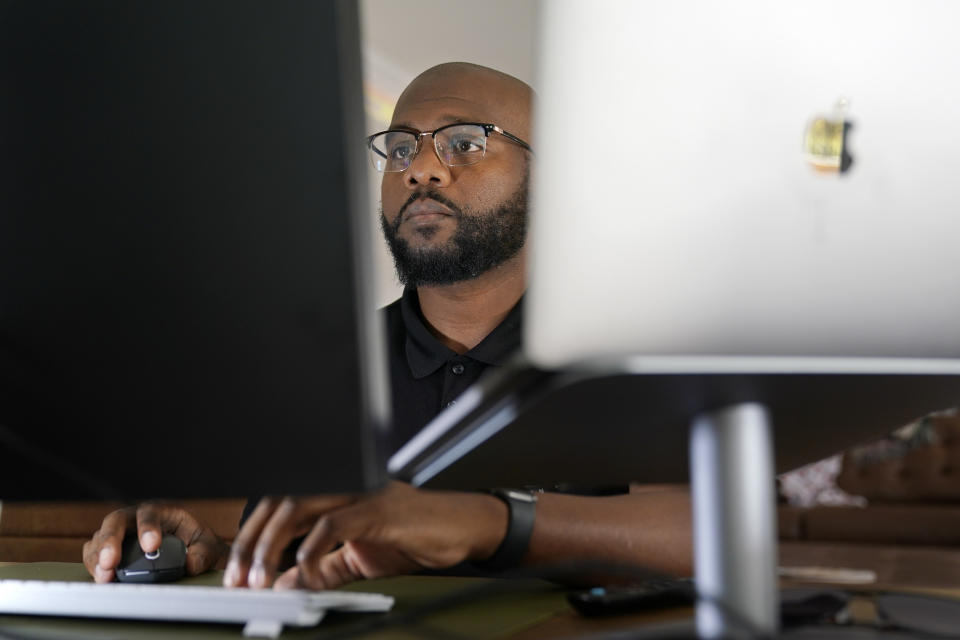 Phillip Slaughter, who served in the U.S. Army for 18 years, works in his home office Nov. 10, 2022, in Clarksville, Tenn. Slaughter got out about four years ago and now works as a recruiter for a tech company. His side hustle is helping to write resumes for recent veterans and aiding service members transition into the civilian workforce. (AP Photo/Mark Humphrey)