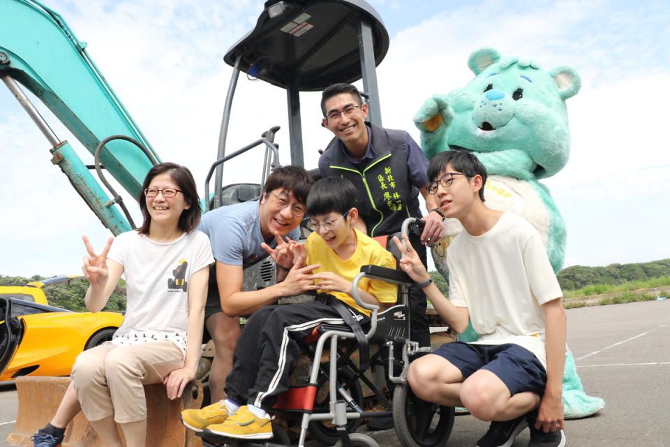 林口區長廖武輝協調一輛怪手車 讓小樂和全家人坐上去。   圖：新北市社會局提供