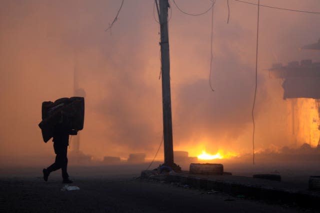 A Palestinian man carries his belongings while fleeing the Naser neighbourhood after Israeli airstrike on Gaza City on Wednesday