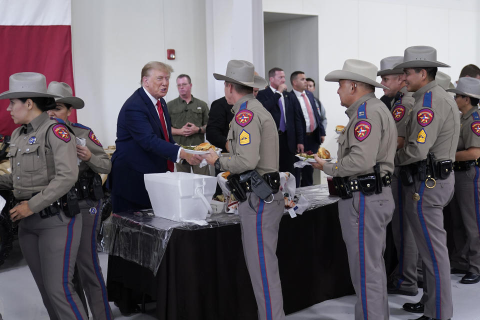 Republican presidential candidate and former President Donald Trump helps serve food to Texas National Guard soldiers, troopers and others who will be stationed at the border over Thanksgiving, Sunday, Nov. 19, 2023, in Edinburg, Texas. (AP Photo/Eric Gay)