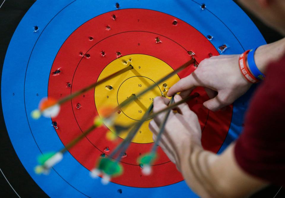A student removes his arrows from a target after he shot during an SPS archery tournament at the Ozark Empire Fair Grounds Central Building on Wednesday, Jan. 31, 2024.