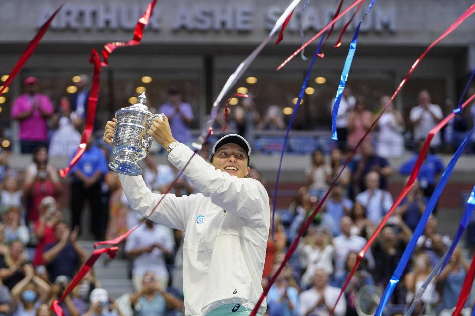 Iga Swiatek, of Poland, holds up the championship trophy after defeating Ons Jabeur, of Tunisia, to win the women's singles final of the U.S. Open tennis championships, Saturday, Sept. 10, 2022, in New York. (AP Photo/Frank Franklin II)
