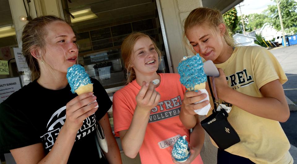 St. Mary Catholic Central volleyball players Lyndsay Conant, a junior; sophomore McKenna Payne and senior Lauren Conant enjoy their frozen custard with teal sprinkles at Lucy's Frozen Custard stand. Lucy's owners Taylor and Griffin Vuvich on Teal Tuesday are offering teal (blue raspberry) dip frozen custard or cone with sprinkles with the proceeds going toward the Teal Attack Volleyball game to raise awareness for ovarian cancer.