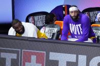 Los Angeles Lakers' LeBron James, left, and Anthony Davis, right, watch play against the Denver Nuggets from the bench during the second half an NBA conference final playoff basketball game, Friday, Sept. 18, 2020, in Lake Buena Vista, Fla. (AP Photo/Mark J. Terrill)