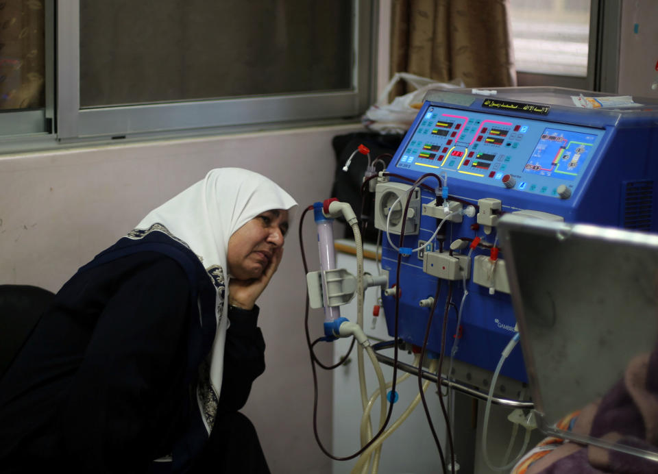 A woman watches her grandson undergo kidney dialysis