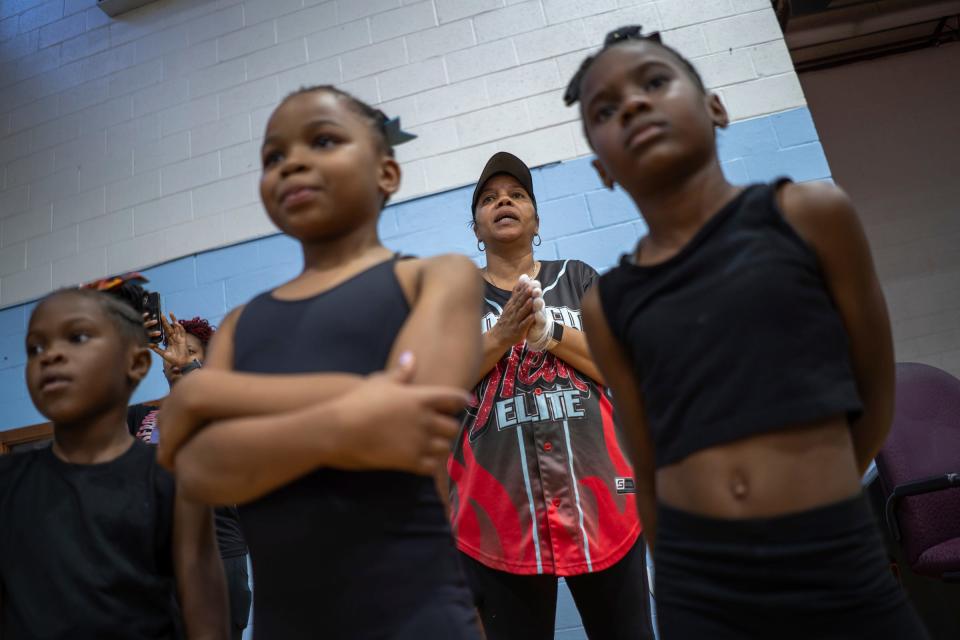 Detroit PAL cheer commissioner Glenda "Coach Pott" Stancil talks with members of the Motor City Heat Elite cheer team Mini Redd Hottz squad during practice at St. Paul Tabernacle Church of God in Christ in Detroit on Aug. 22, 2023.