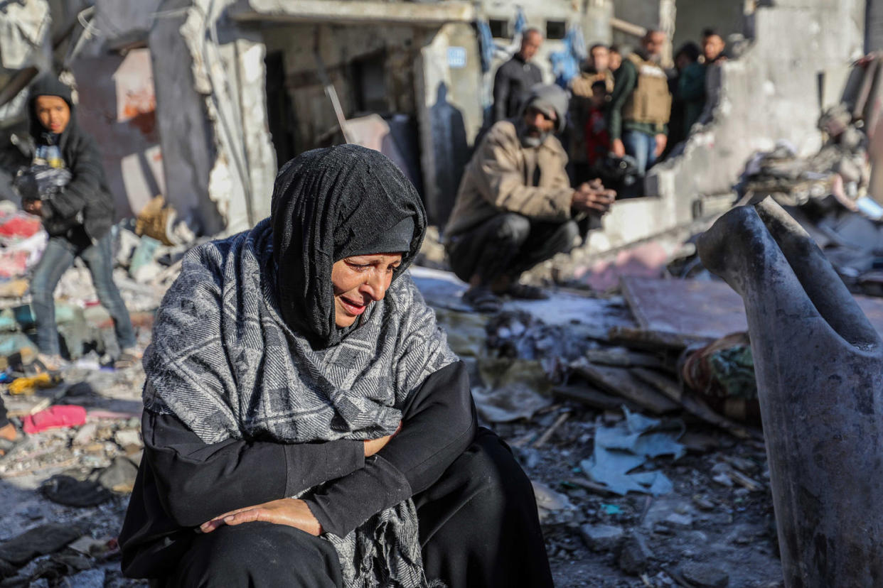 A woman sits amongst damaged homes caused by Israeli air strikes in Rafah, Gaza (Ahmad Hasaballah / Getty Images)