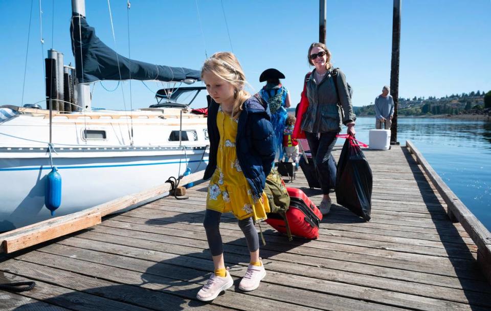 Sarah Mossman of Anderson Island and her daughter unload from Captain Corey Feldon’s “S/V Solution” sailboat as he shuttles residents from Anderson Island to the mainland at Steilacoom, Washington, after the Pierce County ferry M/V Christine Anderson broke down before their vacation flight to Germany on Saturday morning, June 3, 2023.