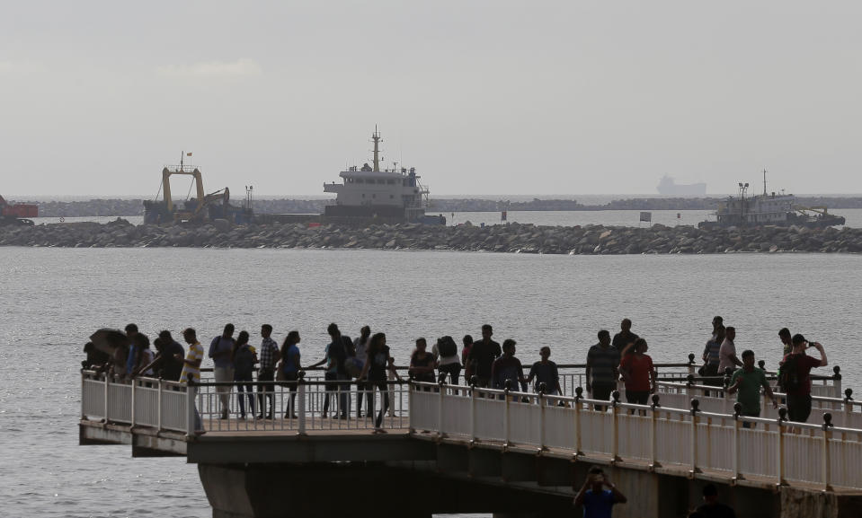 In this Saturday, Nov. 3, 2018, photo, Sri Lankans spend their evening outside the Chinese funded sea reclamation project in Colombo, Sri Lanka. China and India are closely watching the constitutional crisis in Sri Lanka, the latest venue for their struggle for geopolitical supremacy in South Asia. (AP Photo/Eranga Jayawardena)