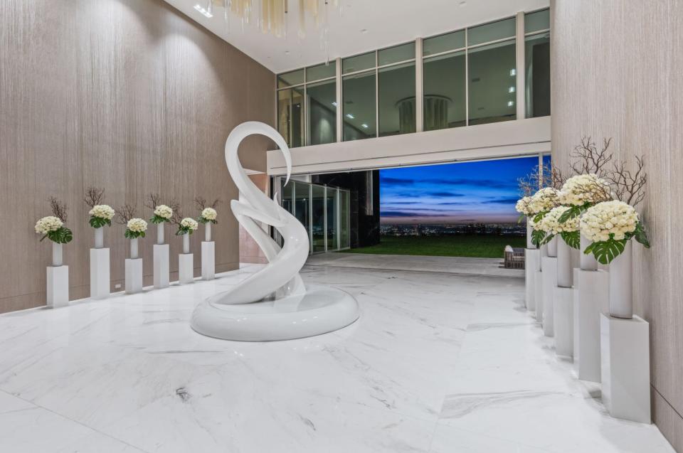 a foyer with a white sculpture in mansion The One Bel Air