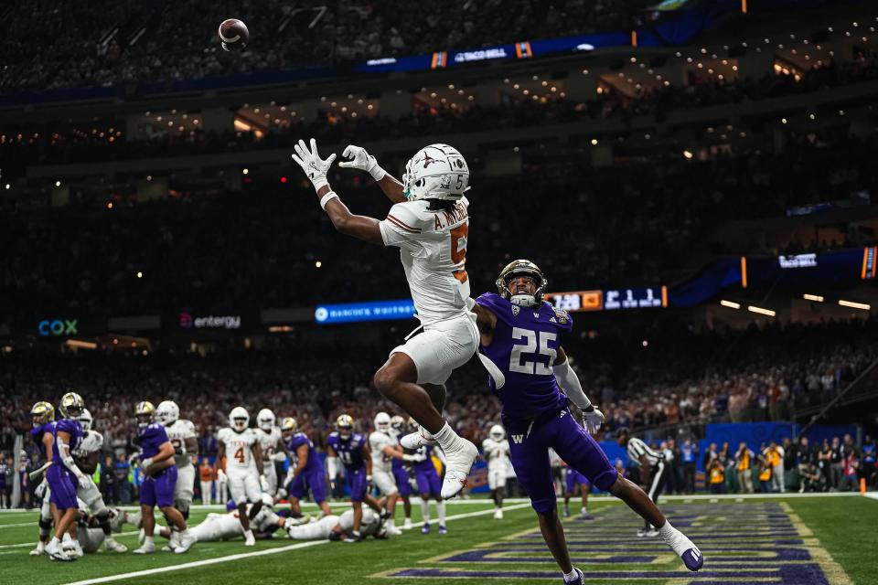 Texas Longhorns wide receiver Adonai Mitchell (5) makes a touchdown catch over Washington cornerback Elijah Jackson during the Sugar Bowl College Football Playoff semifinals game at the Caesars Superdome on Monday, Jan. 1, 2024 in New Orleans, Louisiana. The catch would be the last touchdown for the Longhorns in the 31-37 loss to Washington.